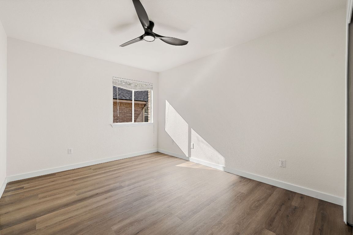 3219 Arroyo Bluff Lane Round Rock, TX 78681 - Photo 21 of 27 a view of an empty room with wooden floor and a window