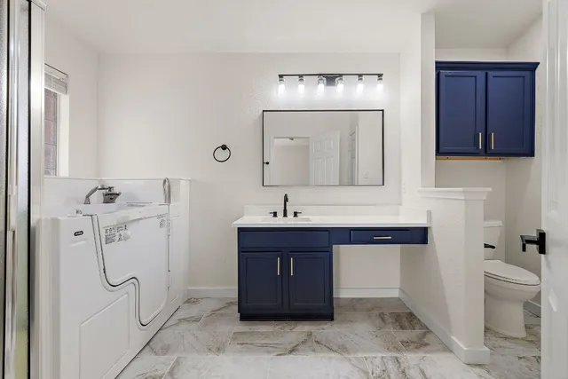 a bathroom with a sink a toilet and shower