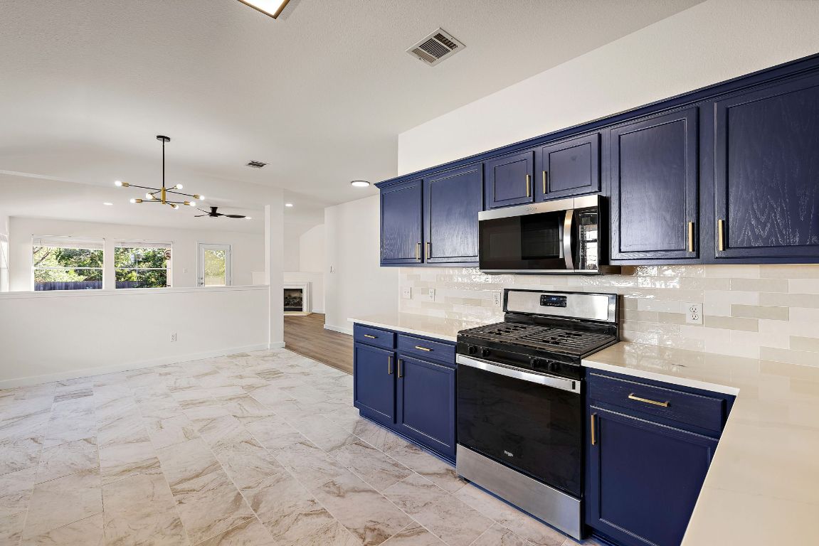 3219 Arroyo Bluff Lane Round Rock, TX 78681 - Photo 9 of 27 a kitchen with stainless steel appliances granite countertop a stove a sink and a microwave