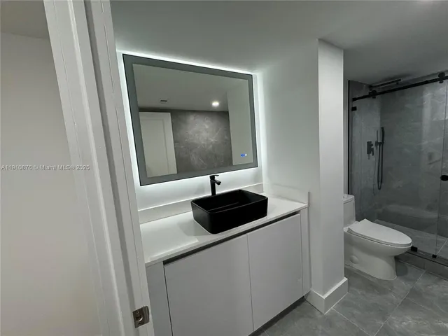 a white toilet sitting next to a shower