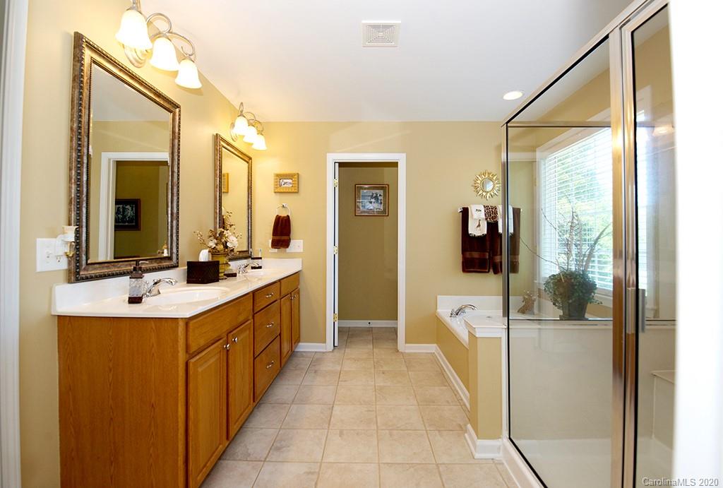 4322 Sunset Rose Drive Fort Mill, SC 29708 - Photo 14 of 34 a large bathroom with a double vanity sink a large mirror and a bathtub
