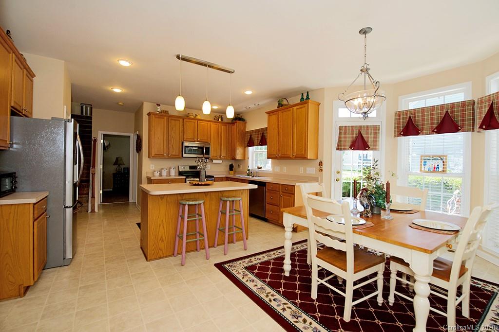 4322 Sunset Rose Drive Fort Mill, SC 29708 - Photo 6 of 34 a kitchen with stainless steel appliances kitchen island granite countertop a sink refrigerator and cabinets