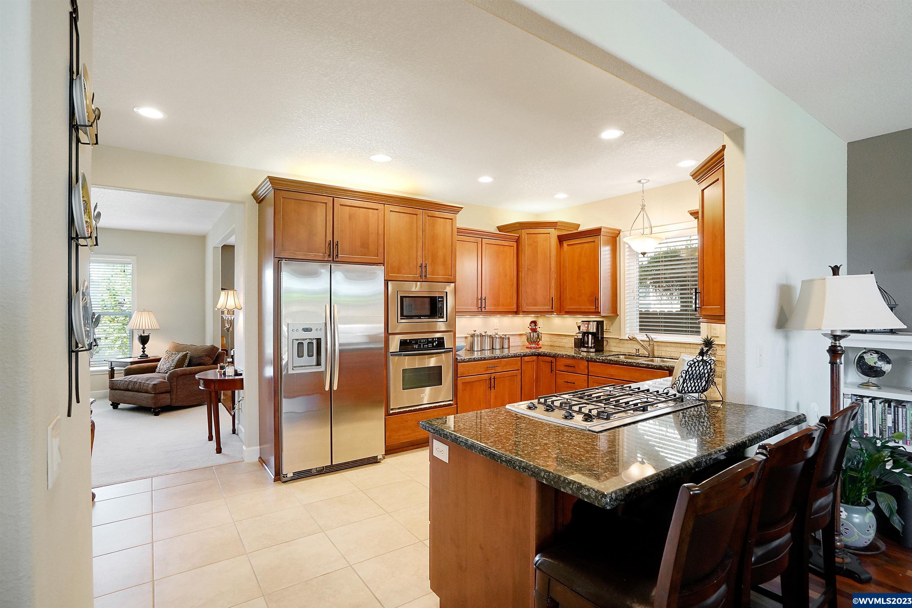 306 Northwest Reed Lane Dallas, OR 97338 - Photo 13 of 42 a kitchen with a refrigerator and a stove top oven