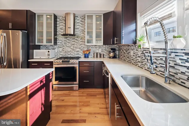 a kitchen with stainless steel appliances granite countertop a sink and a stove
