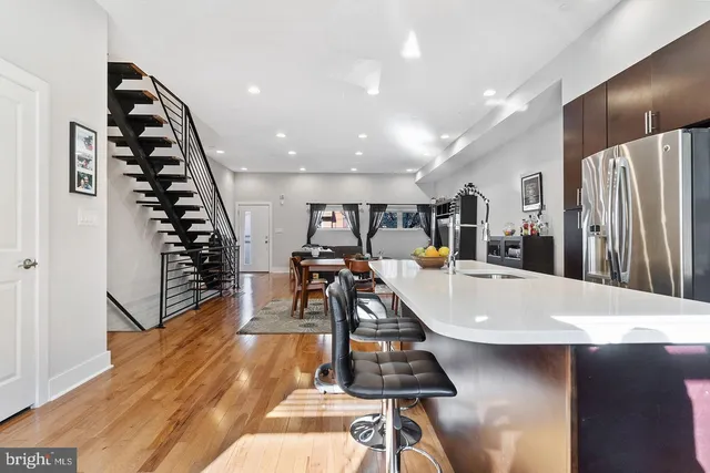 a large room with wooden floor pool table and windows
