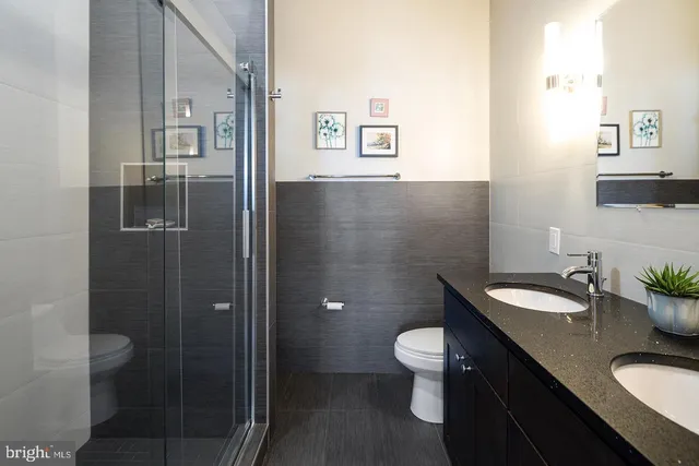 a bathroom with a granite countertop sink toilet and shower