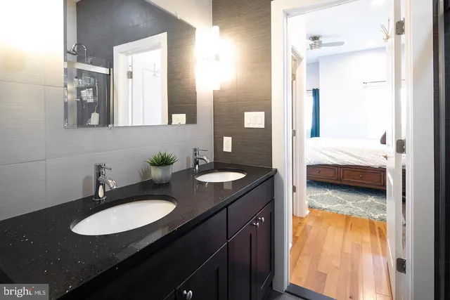 a en suite bathroom with a granite countertop sink and a mirror
