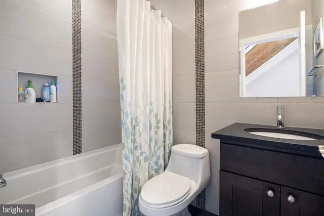 a bathroom with a sink toilet vanity and tub