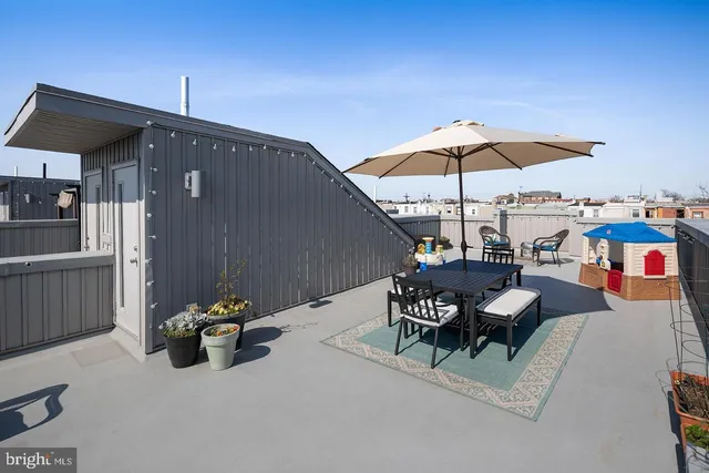 a view of a terrace with furniture and umbrella