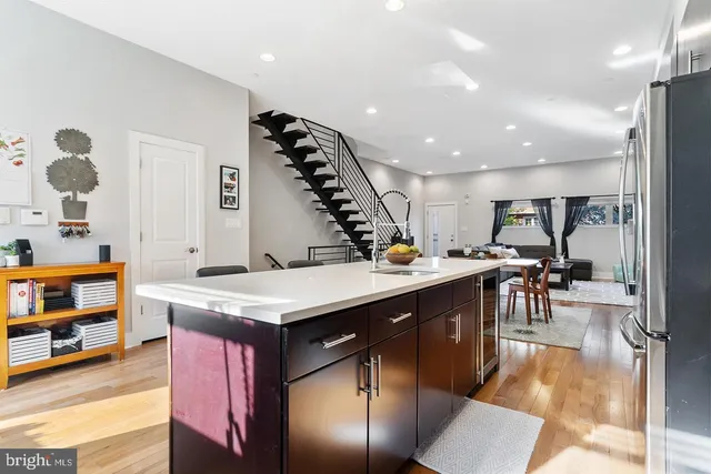 a kitchen with stainless steel appliances granite countertop a kitchen island a stove and a sink