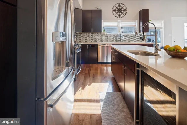 a kitchen with stainless steel appliances granite countertop a sink and a refrigerator