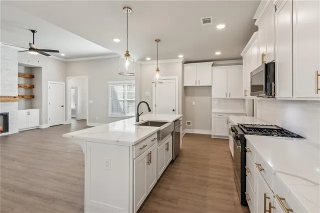 a kitchen with stainless steel appliances granite countertop a sink a stove and a refrigerator