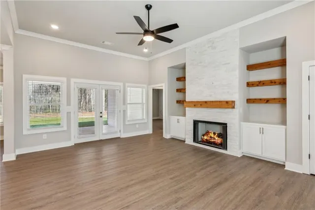 an empty room with wooden floor a fireplace and a window