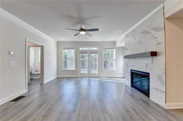 a view of an empty room with wooden floor fireplace and a window