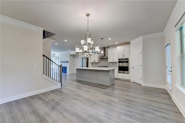a view of kitchen and kitchen with a sink wooden floor and chandelier