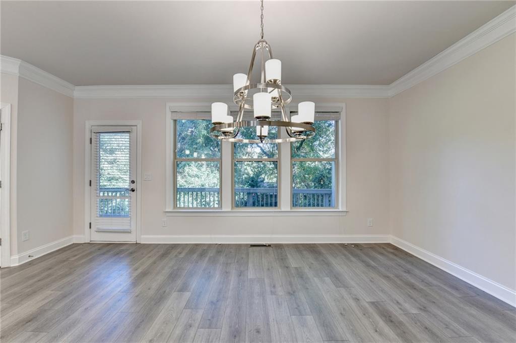 3159 Clairebrooke Avenue Atlanta, GA 30341 - Photo 18 of 36 an empty room with wooden floor chandelier and windows