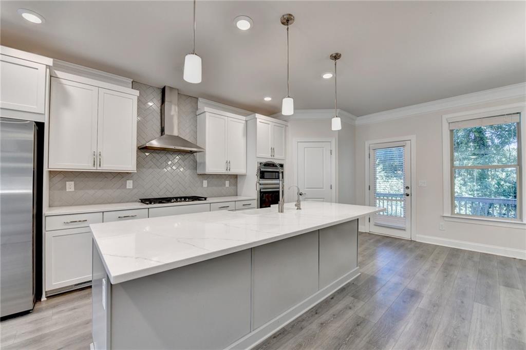 3159 Clairebrooke Avenue Atlanta, GA 30341 - Photo 6 of 36 a large kitchen with kitchen island a stove a sink a center island and wooden floor