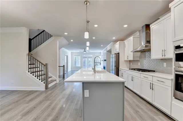 a kitchen with stainless steel appliances kitchen island a white cabinets and a sink