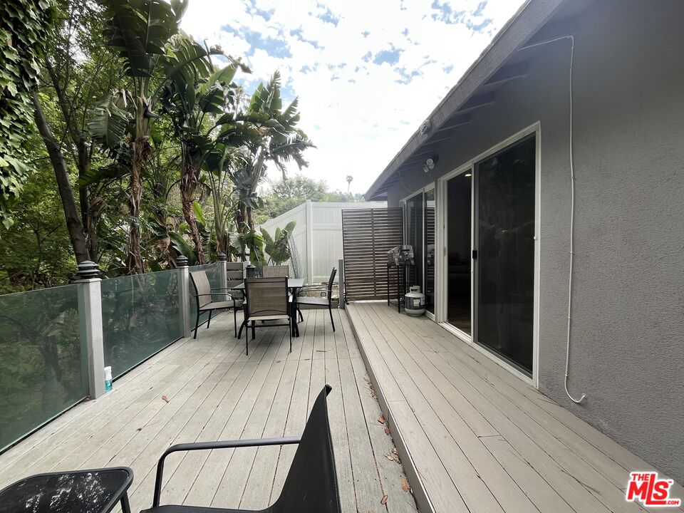 3708 Woodcliff Road Sherman Oaks, CA 91403 - Photo 11 of 14 a view of a patio with table and chairs with wooden floor and fence