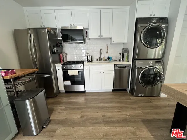 a kitchen with a refrigerator sink and cabinets
