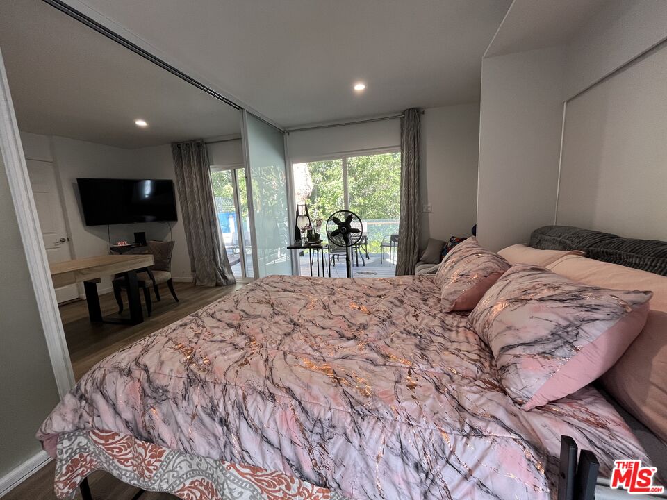 3708 Woodcliff Road Sherman Oaks, CA 91403 - Photo 4 of 14 a bedroom with a bed and a flat tv screen on the dresser
