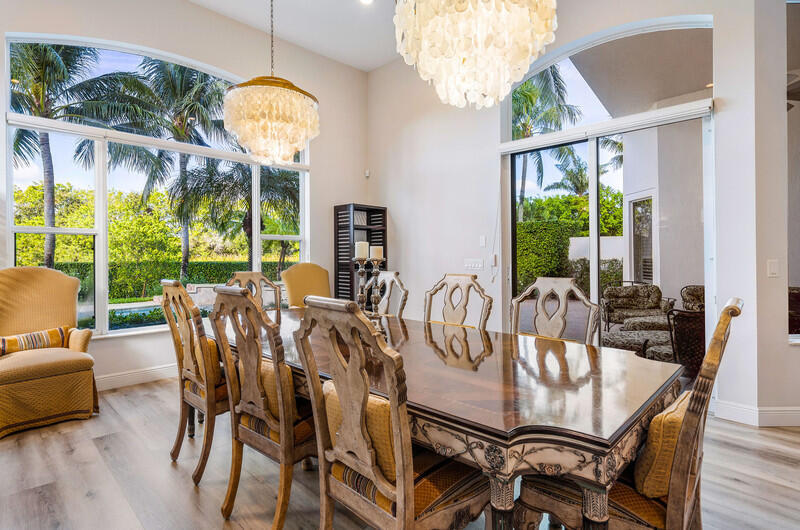 14364 Stroller Way Wellington, FL 33414 - Photo 19 of 47 a view of a dining room with furniture a chandelier and wooden floor