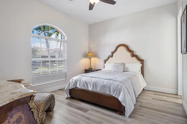 front view of house with a yard and palm trees