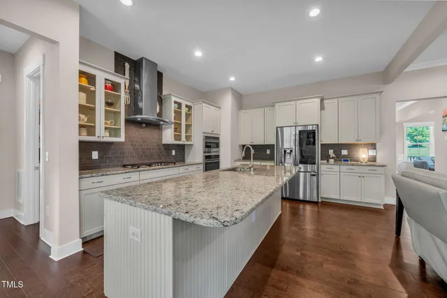 a large kitchen with stainless steel appliances granite countertop a sink stove and refrigerator
