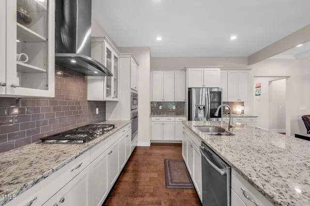 a kitchen with stainless steel appliances granite countertop a stove a sink and a microwave