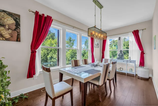 a view of a dining room with furniture large windows and wooden floor