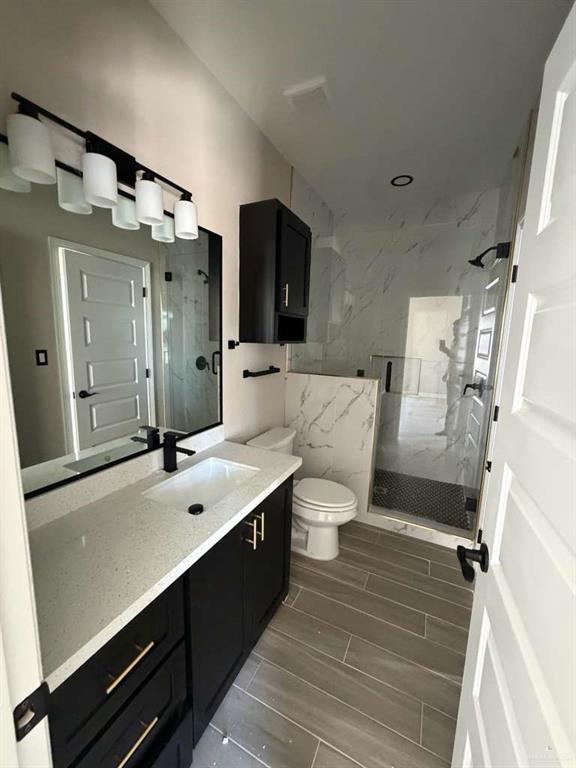 Lot 23 Farrell Road, Unit 1 Weslaco, TX 78596 - Photo 6 of 9 a bathroom with a double vanity sink mirror and toilet