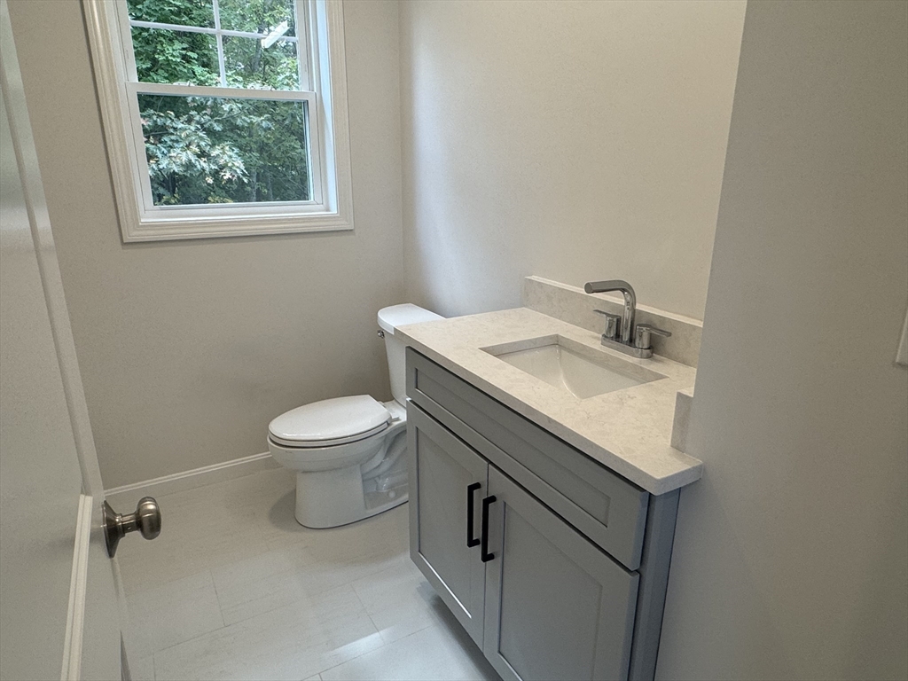 19 Ambrose Way, Unit 19 Shirley, MA 01464 - Photo 11 of 21 a bathroom with a granite countertop toilet a sink and a window