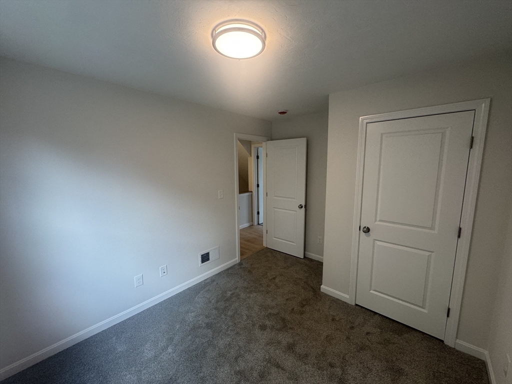 19 Ambrose Way, Unit 19 Shirley, MA 01464 - Photo 9 of 21 an empty room with closet area and windows