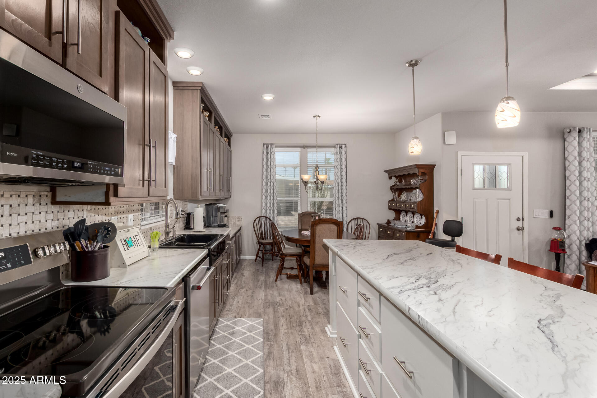 2929 East Main Street, Unit 160 Mesa, AZ 85213 - Photo 4 of 29 a large kitchen with stainless steel appliances granite countertop a stove a sink dishwasher a dining table and chairs with wooden floor