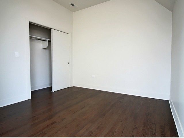 1418 West Addison Street, Unit 101 Chicago, IL 60613 - Photo 5 of 5 an empty room with wooden floor and closet