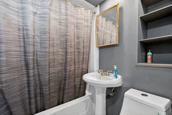 a bathroom with a sink a toilet and mirror
