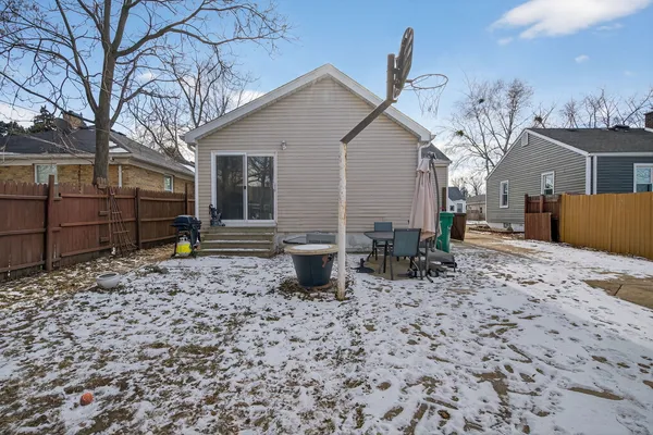 a backyard of a house with barbeque oven and outdoor seating