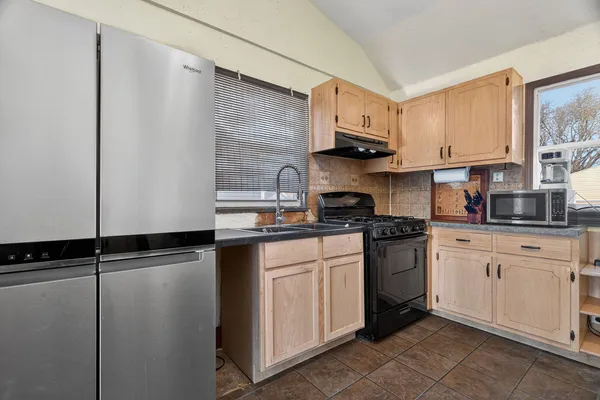 a kitchen with stainless steel appliances granite countertop a sink a stove a refrigerator a microwave and cabinets