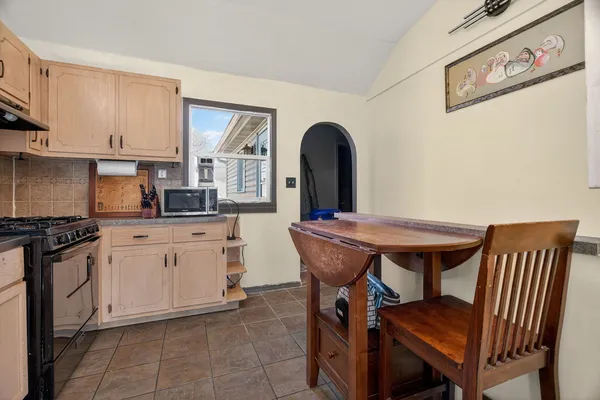 a kitchen with stainless steel appliances granite countertop a white stove top oven and white cabinets
