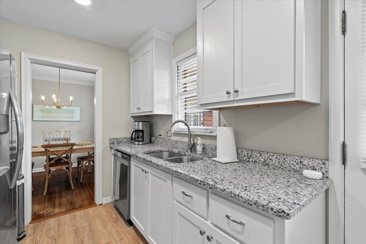 4491 Garnett Road Memphis, TN 38117 - Photo 10 of 32 Modern kitchen featuring white cabinetry, light-toned granite countertops, and stainless steel appliances