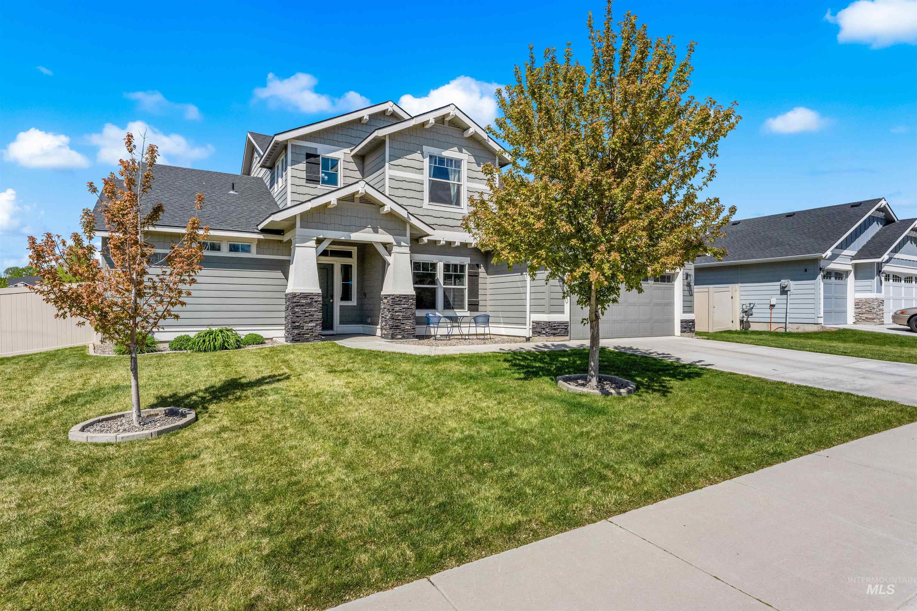 10890 West Sharpthorn Street Boise, ID 83709 - Photo 1 of 50 Two-story residence featuring light gray siding, dark gray roof, and stone-clad porch columns