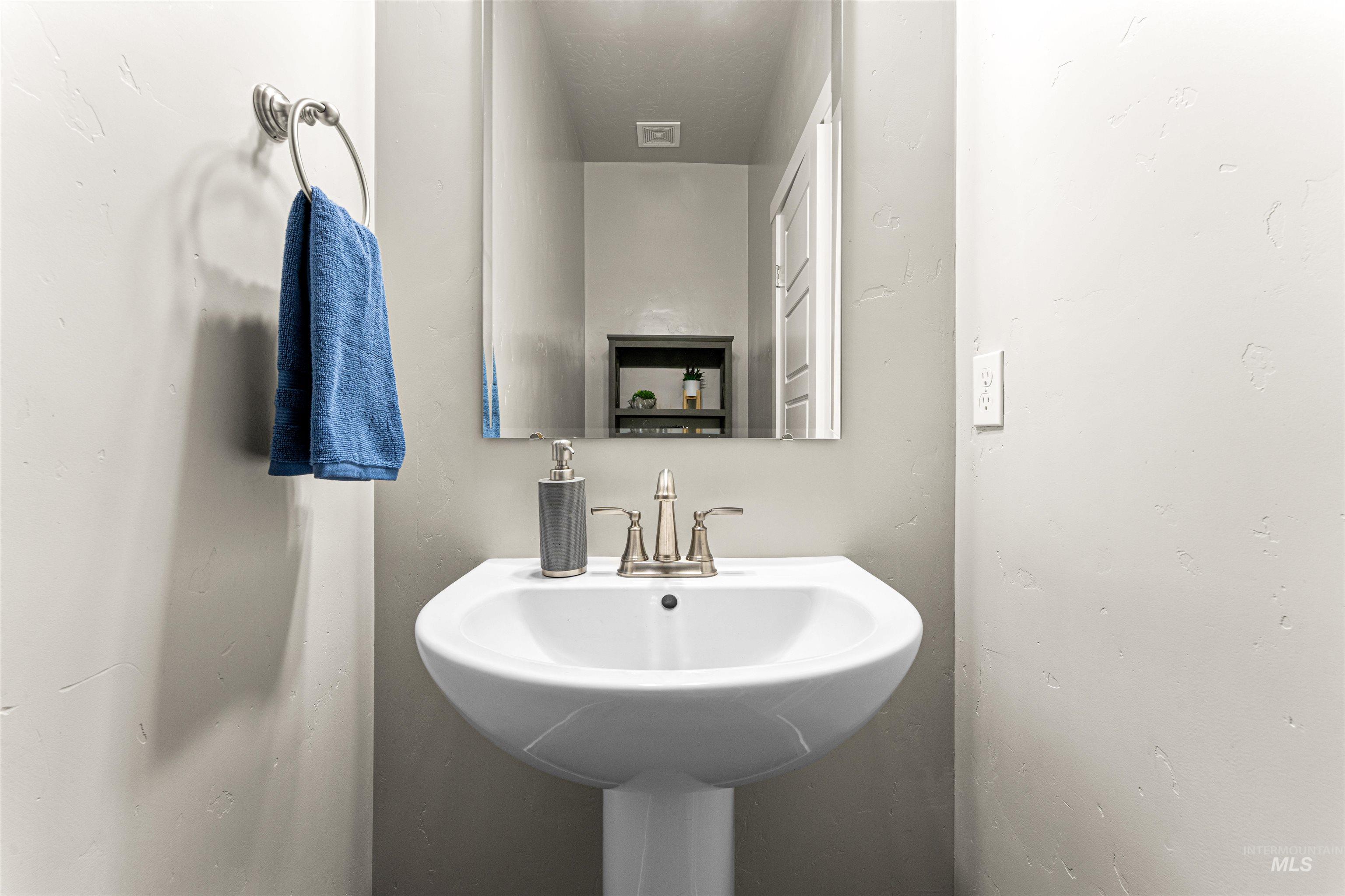10890 West Sharpthorn Street Boise, ID 83709 - Photo 31 of 50 Pedestal sink with brushed nickel faucet, framed mirror, and light gray wall finish
