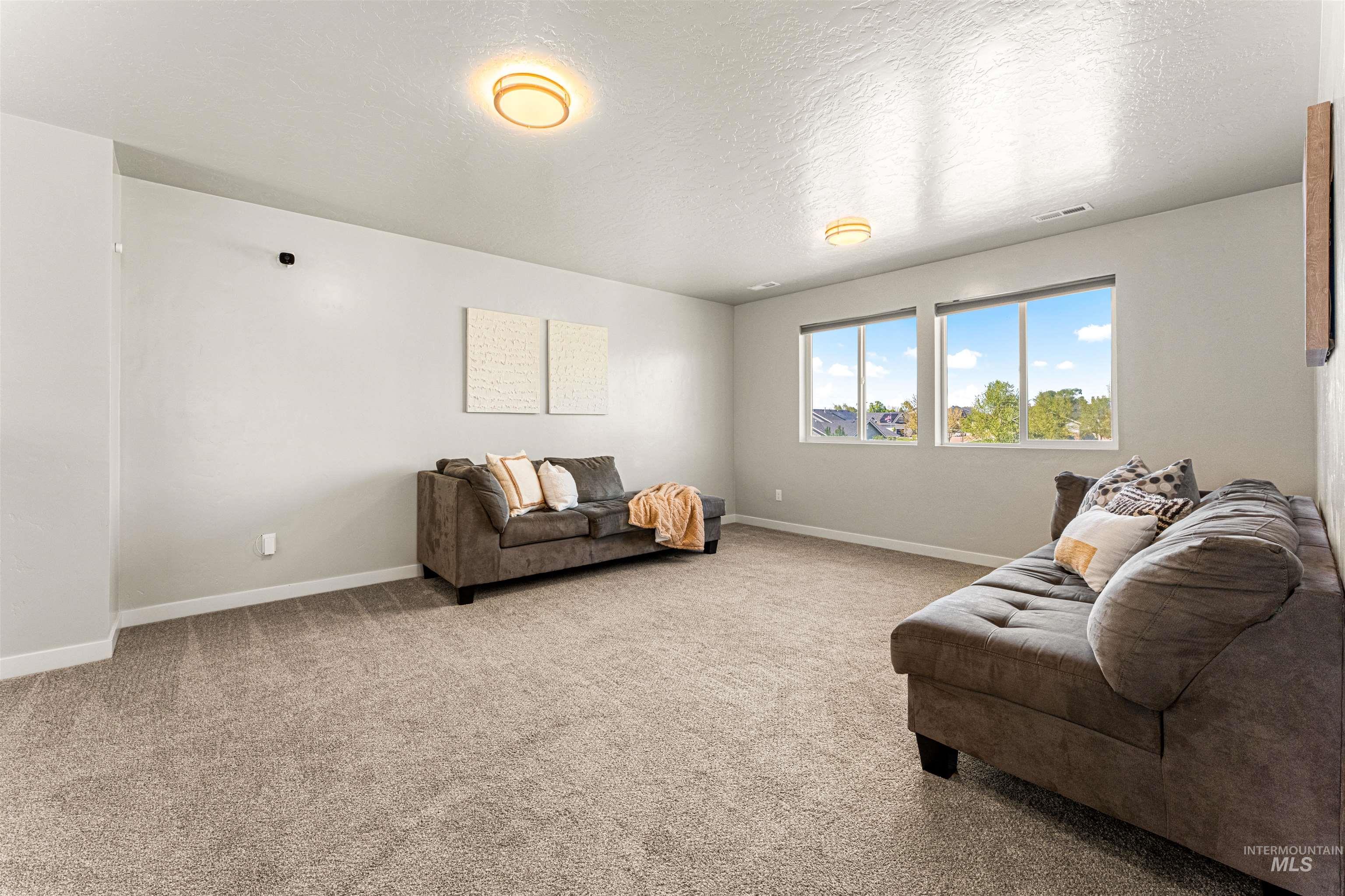 10890 West Sharpthorn Street Boise, ID 83709 - Photo 34 of 50 Spacious room featuring neutral carpeting, light-colored walls, and two flush-mount ceiling lights