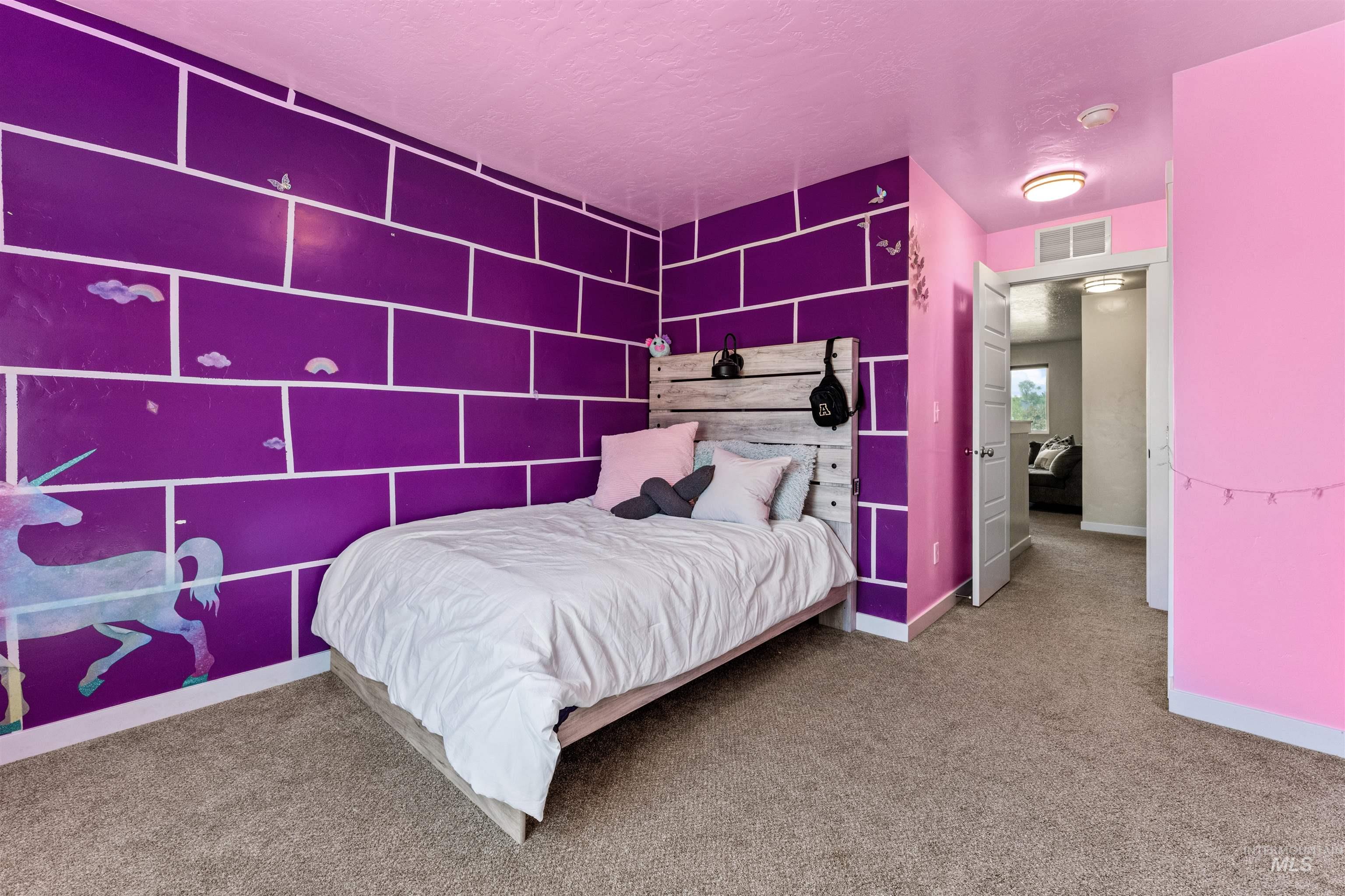 10890 West Sharpthorn Street Boise, ID 83709 - Photo 36 of 50 Carpeted room featuring a purple accent wall with white block patterning, a light pink ceiling, light pink walls, a white-paneled door, and a flush-mount ceiling light