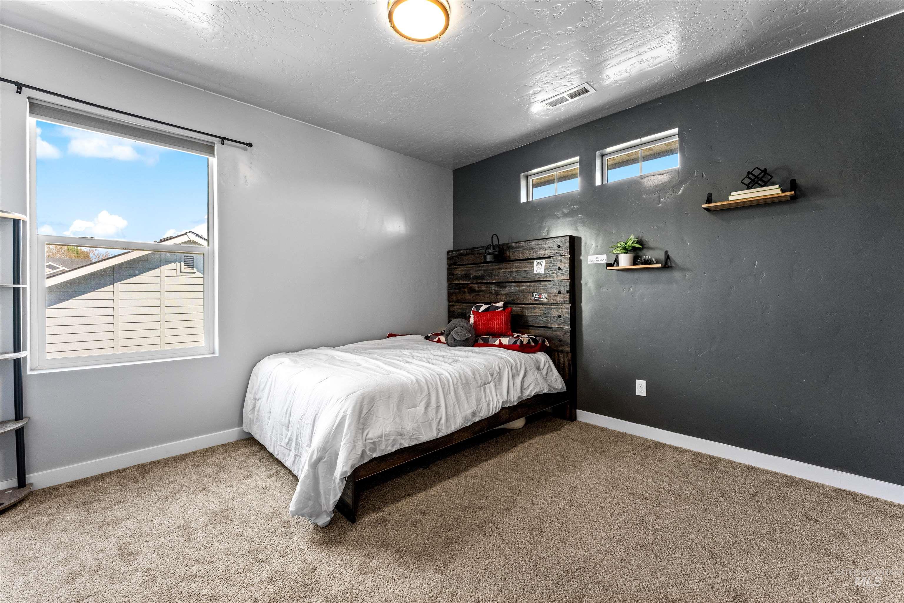 10890 West Sharpthorn Street Boise, ID 83709 - Photo 37 of 50 Bedroom featuring a large window, neutral carpet, and a dark accent wall with two high-set windows