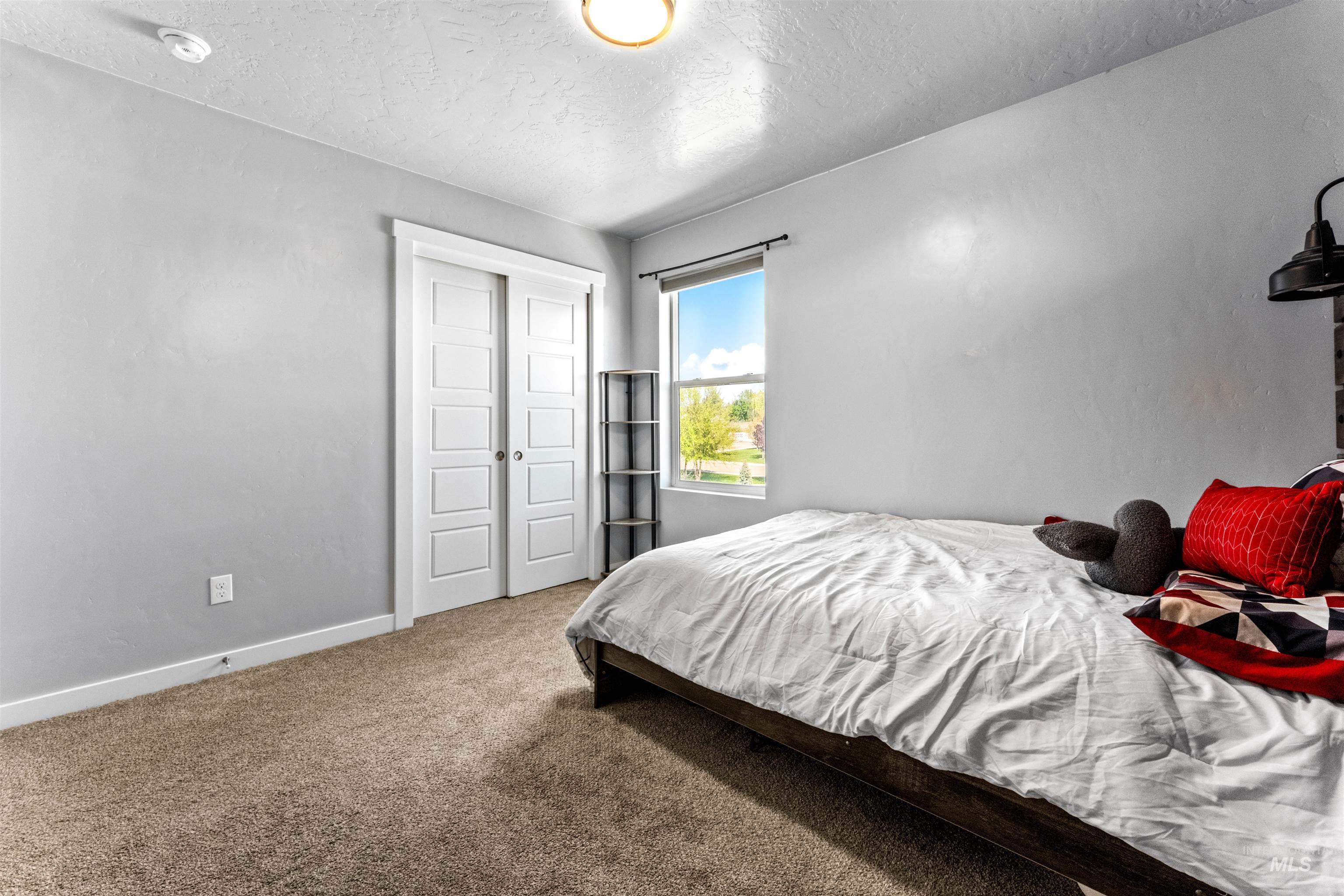 10890 West Sharpthorn Street Boise, ID 83709 - Photo 38 of 50 Carpeted room featuring a single window, white trim, and a ceiling-mounted light fixture
