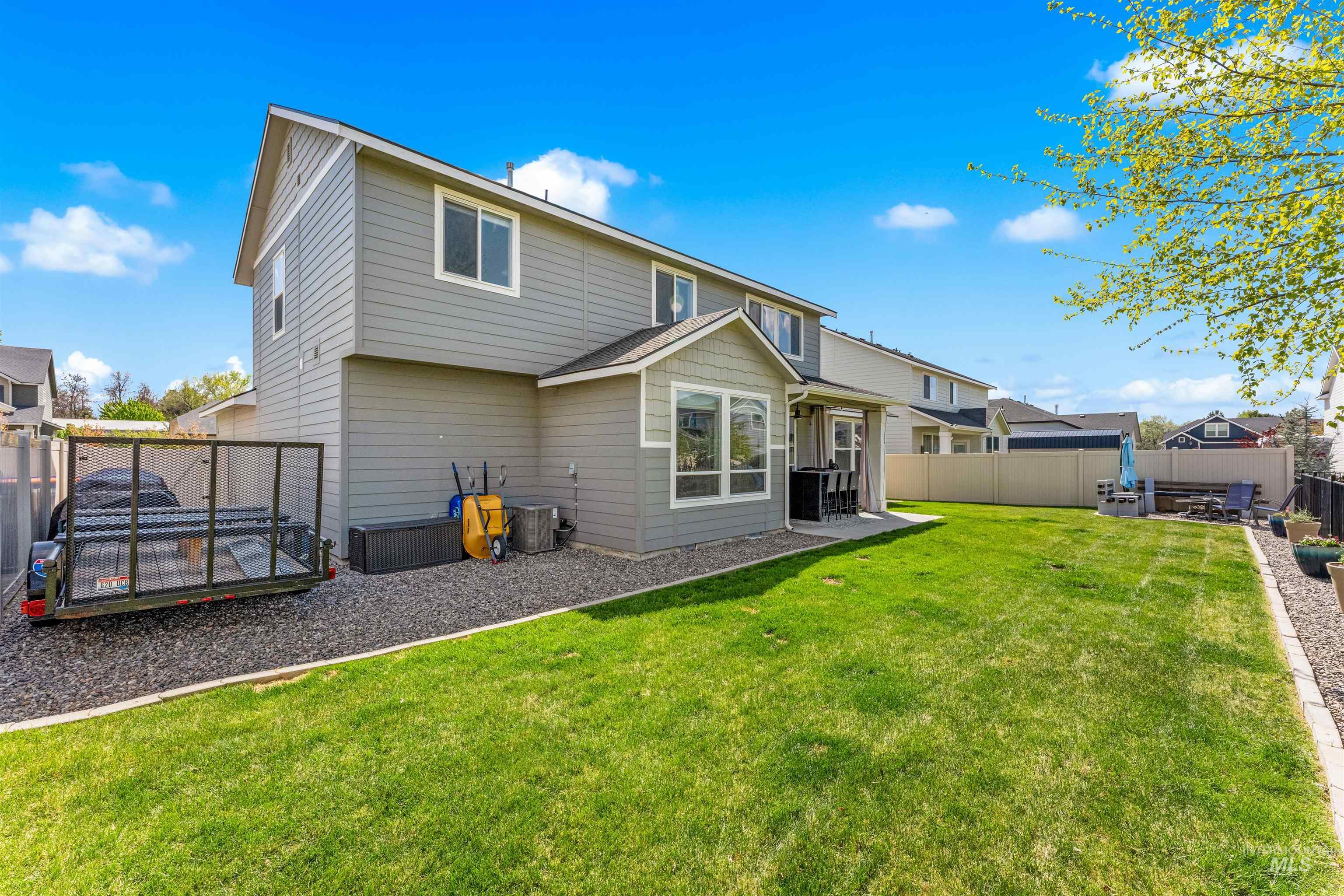 10890 West Sharpthorn Street Boise, ID 83709 - Photo 48 of 50 Expansive backyard featuring a manicured lawn, a concrete patio, and a dedicated gravel area