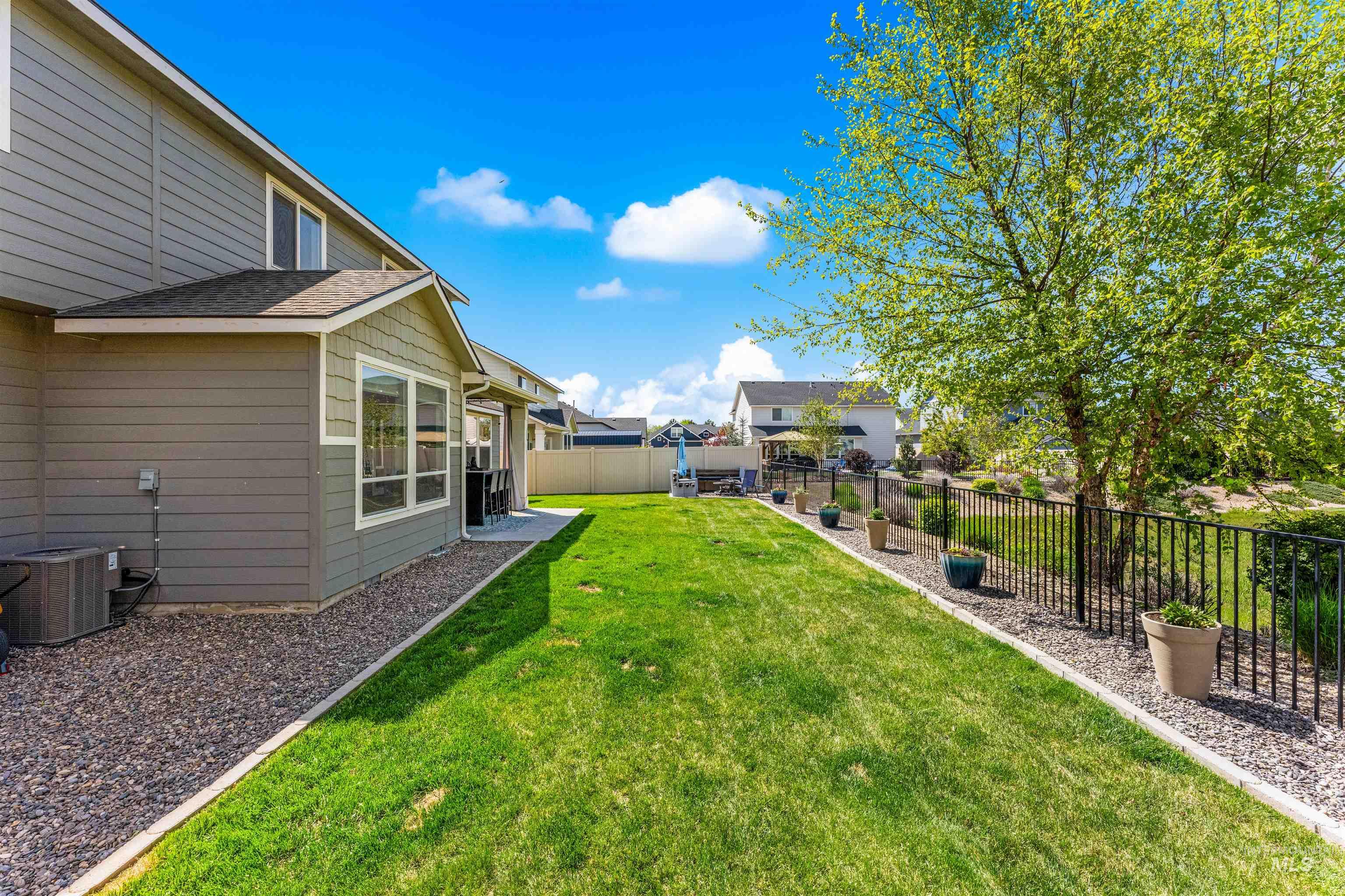 10890 West Sharpthorn Street Boise, ID 83709 - Photo 49 of 50 Expansive green lawn with a gravel border, featuring a mature tree