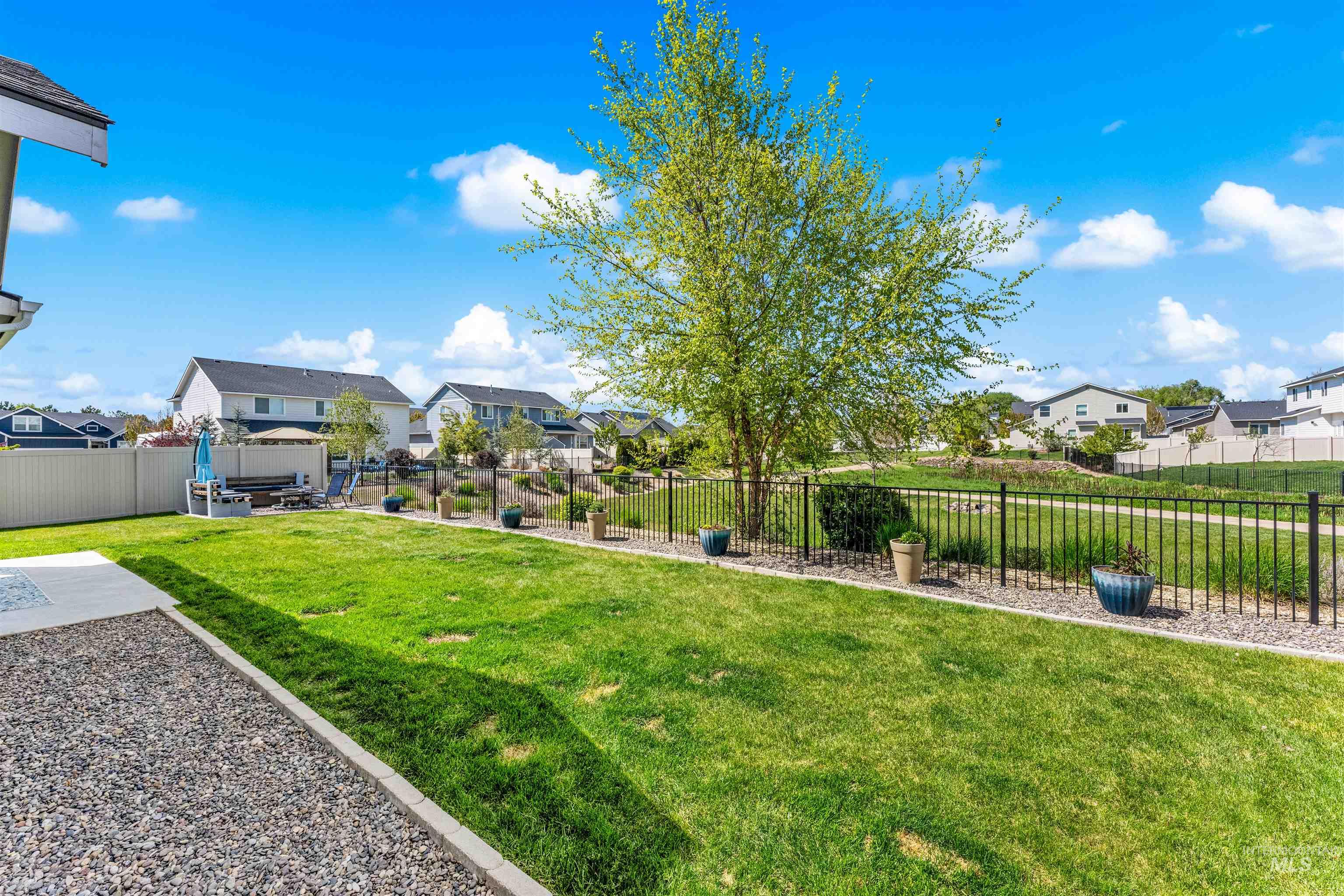 10890 West Sharpthorn Street Boise, ID 83709 - Photo 50 of 50 Expansive backyard featuring a manicured lawn, a large shade tree, and a concrete patio