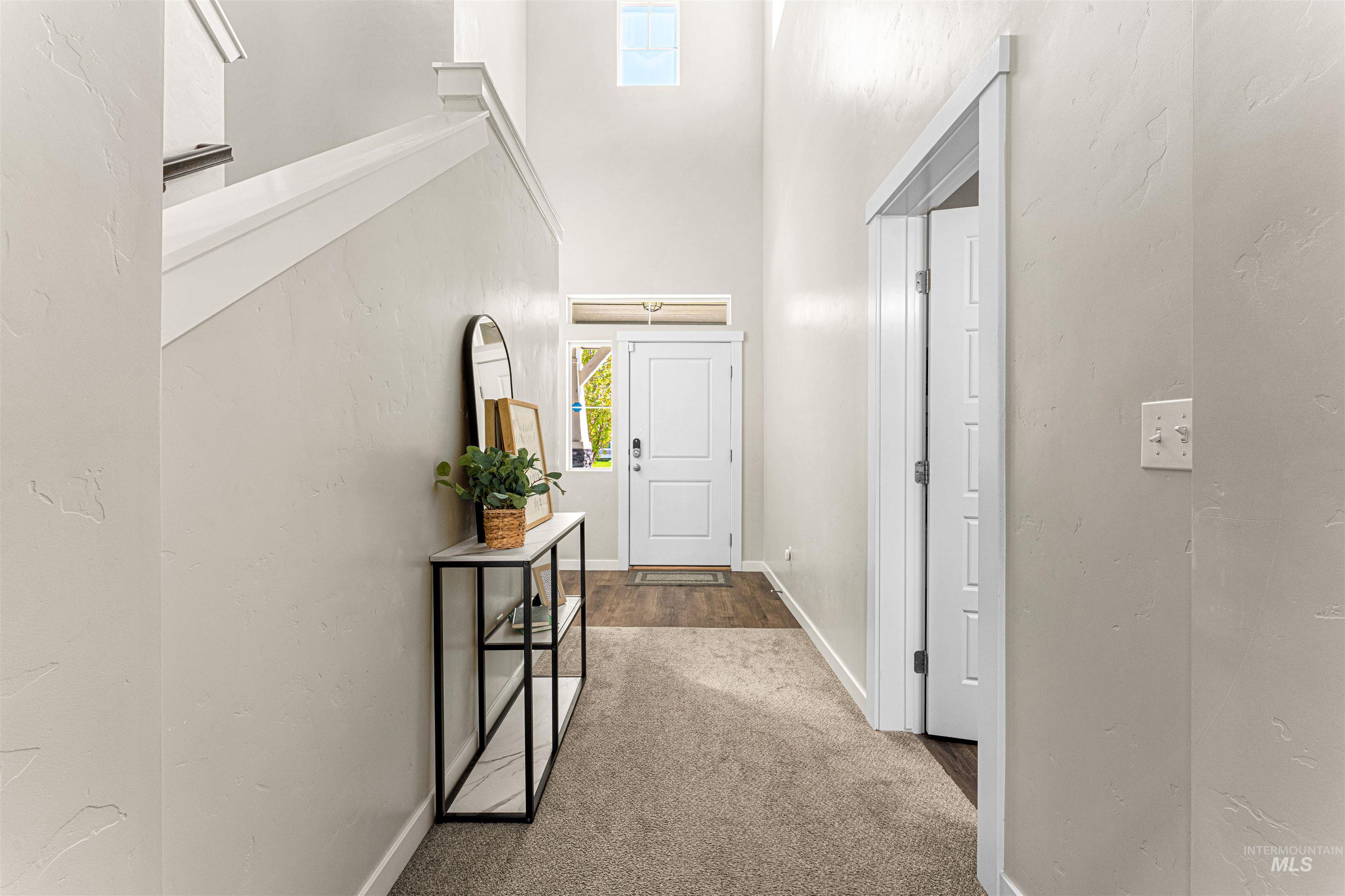 10890 West Sharpthorn Street Boise, ID 83709 - Photo 5 of 50 Entryway featuring a two-story ceiling, a white paneled door with transom window, and a carpeted floor